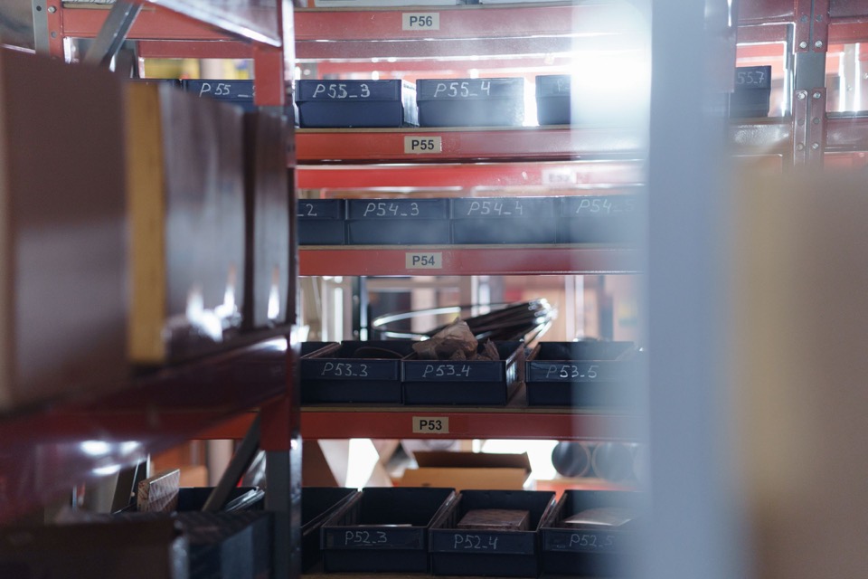Labelled warehouse shelving used for organised sourcing and inventory review.