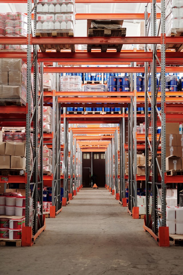 Organised warehouse shelving and pallets supporting customer supply coordination.